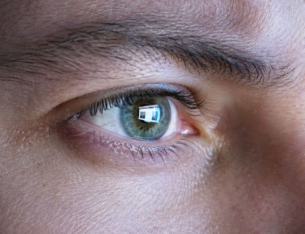 Detail eines menschlichen Auges mit sichtbarer Iris und Lichtreflexen