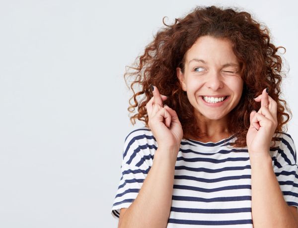 Junge Frau mit Locken und gestreiftem Shirt lächelt in die Kamera.