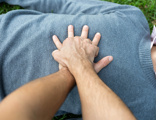 Zwei Hände reanimieren eine Person