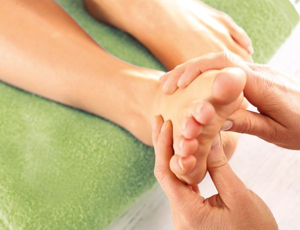 Jemandem wird eine Fußreflexzonenmassage gegeben.