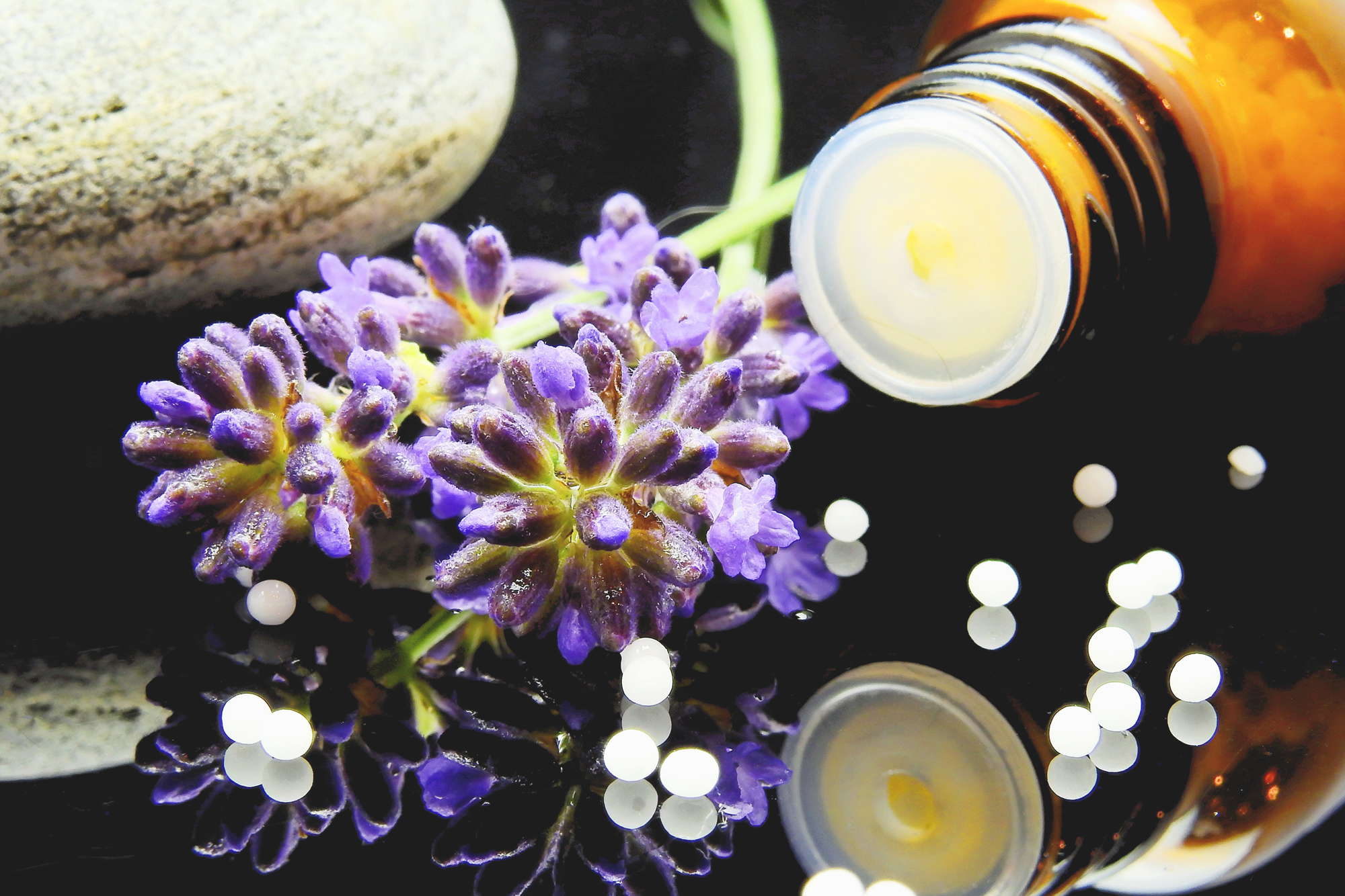 Vielfältige Pflanzen, Blüten und Kräuter mit Glasgefäß als Darstellung pflanzlicher Wirkstoffe und Naturmedizin