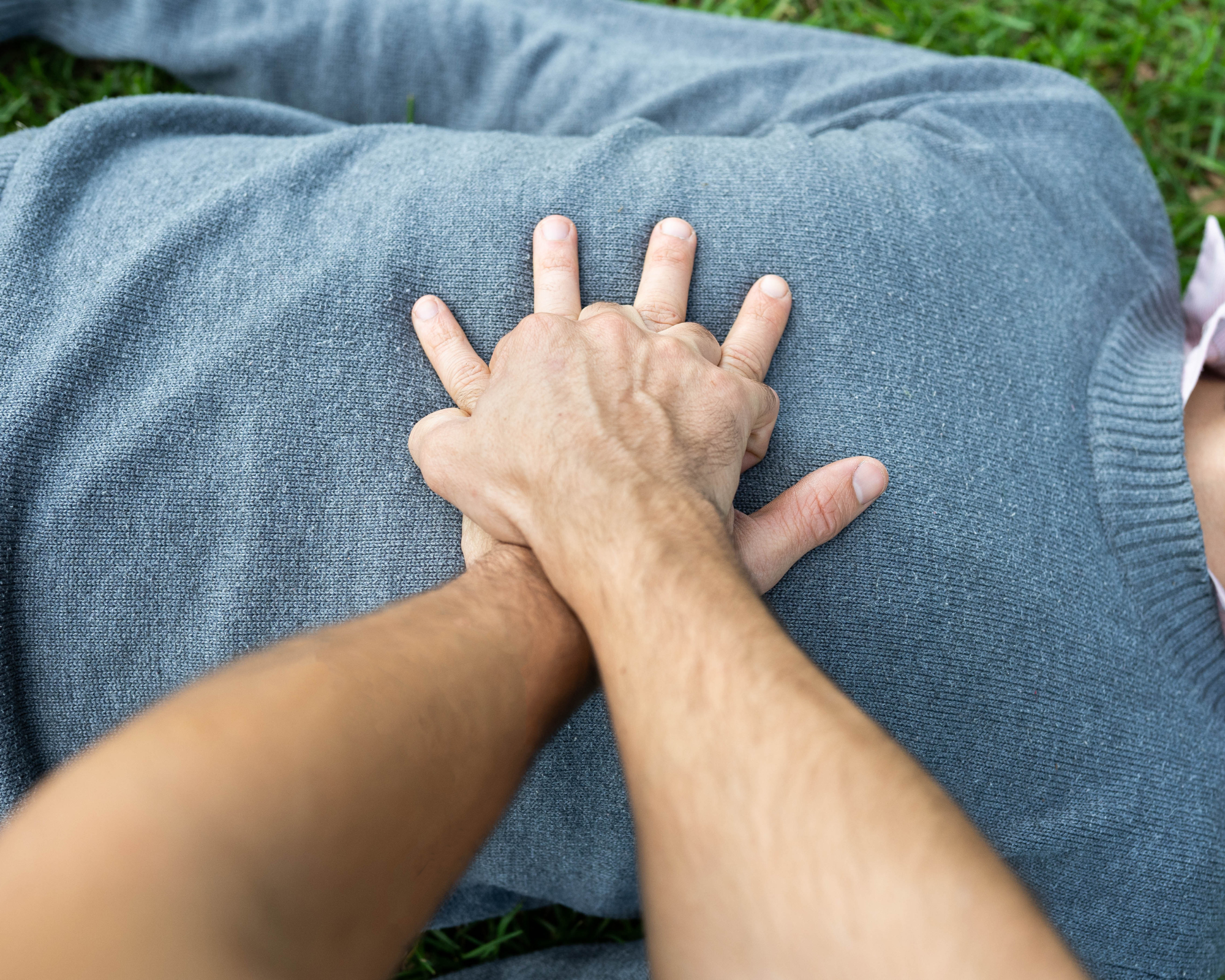 Zwei Hände reanimieren eine Person